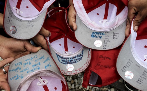 Los nombres de los miembros de "los gorras rojas" apuntados en el anverso de las viseras del grupo Alejandro García