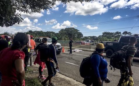 Migrantes observan el cadáver de un compatriota que cayó de un vehículo y fue arrastrado por otros dos, en la carretera entre Tapachula y Huixtla Rafael Sánchez
