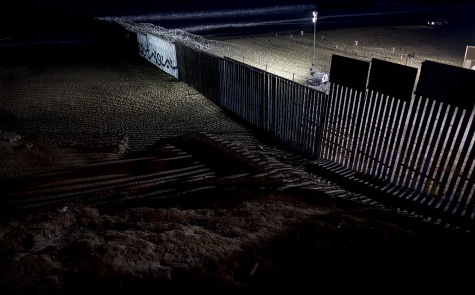 El muro fronterizo que separa Tijuana de San Diego, entre México y USA, protegido por una malla metálica recién instalada, iluminado por la noche Simone Dalmasso