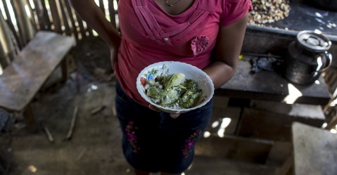 María Isabel García, 27, enseña el desayuno de repollo con tortilla que consumió la familia, en el caserío El Centro, aldea de Tierra Blanca Simone Dalmasso