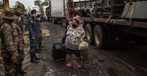 Una migrante observa el despliegue de fuerzas del orden guatemaltecas mientras transita en el primer tramo de recorrido de la caravana, pasada la frontera del Corinto, el 02 de octubre Esteban Biba/EFE