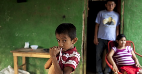 Brayan René Espino Ramírez, de 8 años, posa enfrente de sus padres, en el caserío Ushurjá, Camotán, departamento de Chiquimula, en mayo 2016 Simone Dalmasso