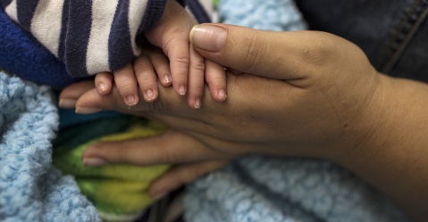 Julia sostiene la mano de su hijo menor de 20 días. Después de que se observaran las indicaciones médicas durante el embarazo y un parto cesáreo, el riesgo del bebé de exposición al VIH es prácticamente nulo. Simone Dalmasso